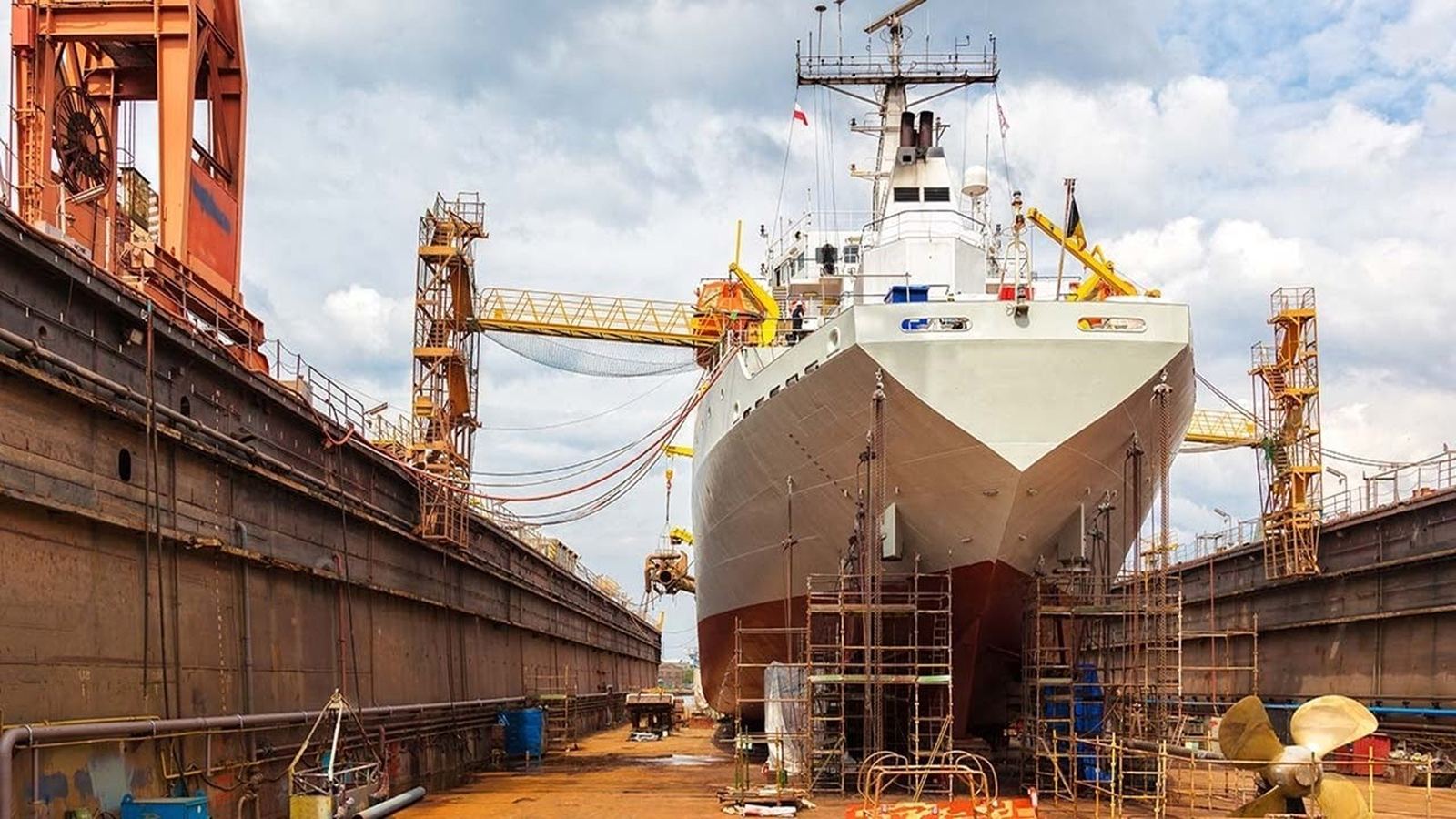 Ship in dry dock surrounded by scaffolding for hull work