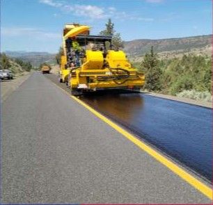 Paving machine laying asphalt on a road.
