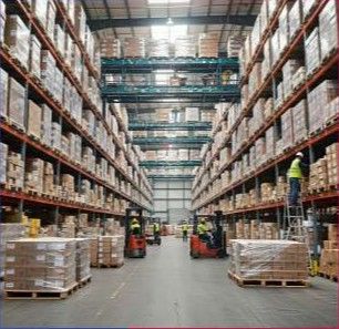 Industrial warehouse interior with high racking and forklifts.