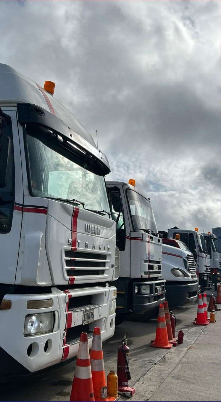 Heavy-duty trucks lined up with safety cones and extinguishers alongside.