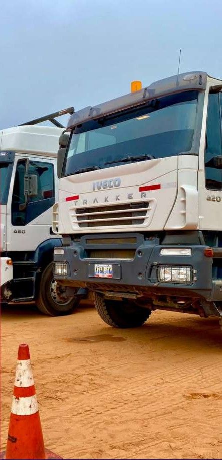 Heavy-duty trucks in a yard with safety cones.